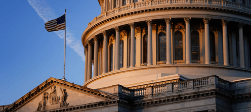 The United States Capitol building dome against a blue sky